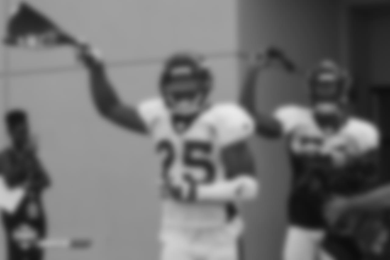Cornerback Chris Harris Jr. (25) and inside linebacker Brandon Marshall (54) run out of the facility waving Alzheimer's Awareness towels during the seventh day of training camp on August 4, 2018, at UCHealth Training Center. Saturday was Alzheimer's Awareness Day at camp.