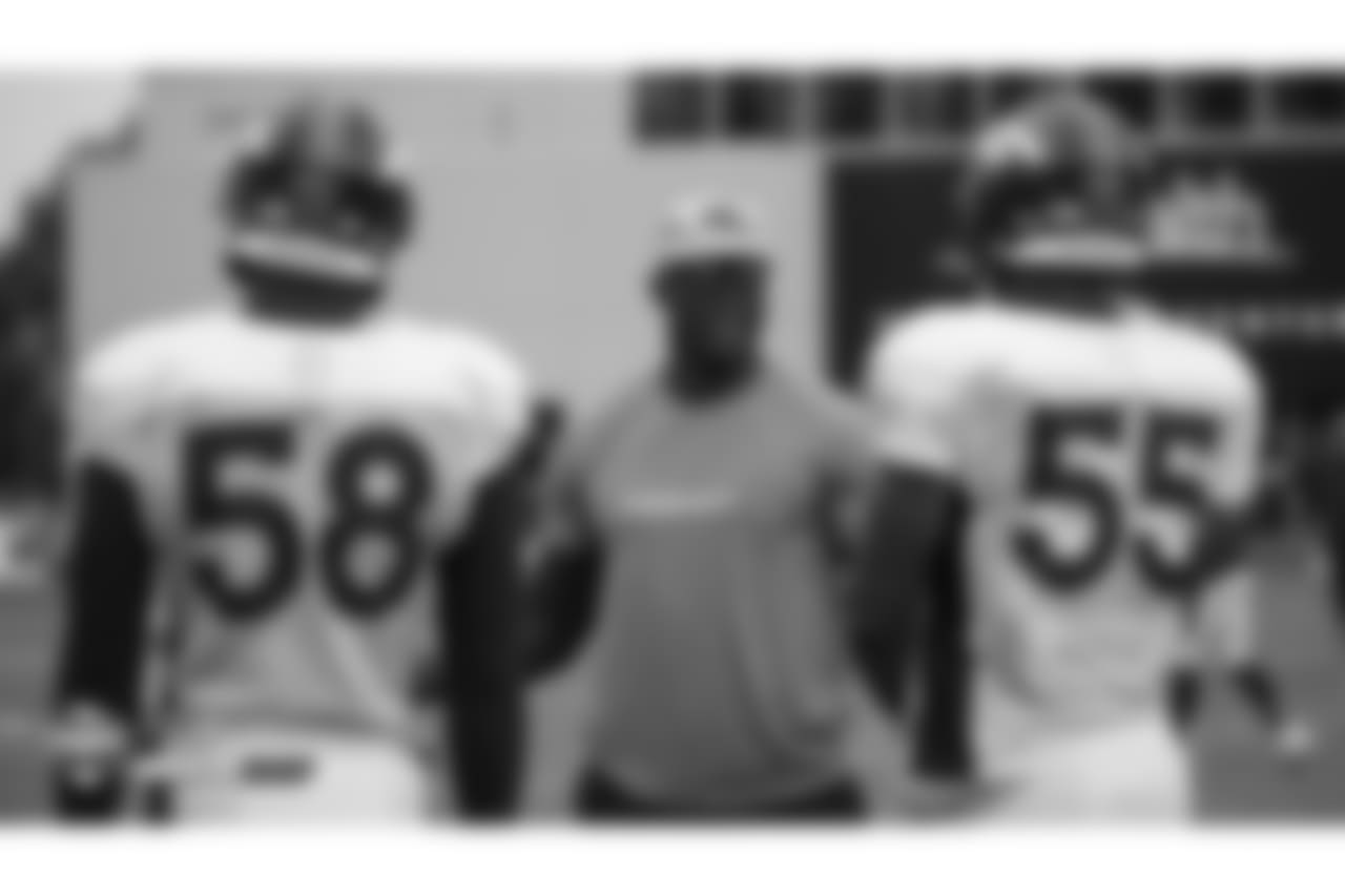 Former Broncos outside linebacker and Pass Rush Consultant DeMarcus Ware talks with outside linebacker Von Miller (58) and outside linebacker Bradley Chubb (55) at the sixth day of training camp on August 3, 2018, at UCHealth Training Center.