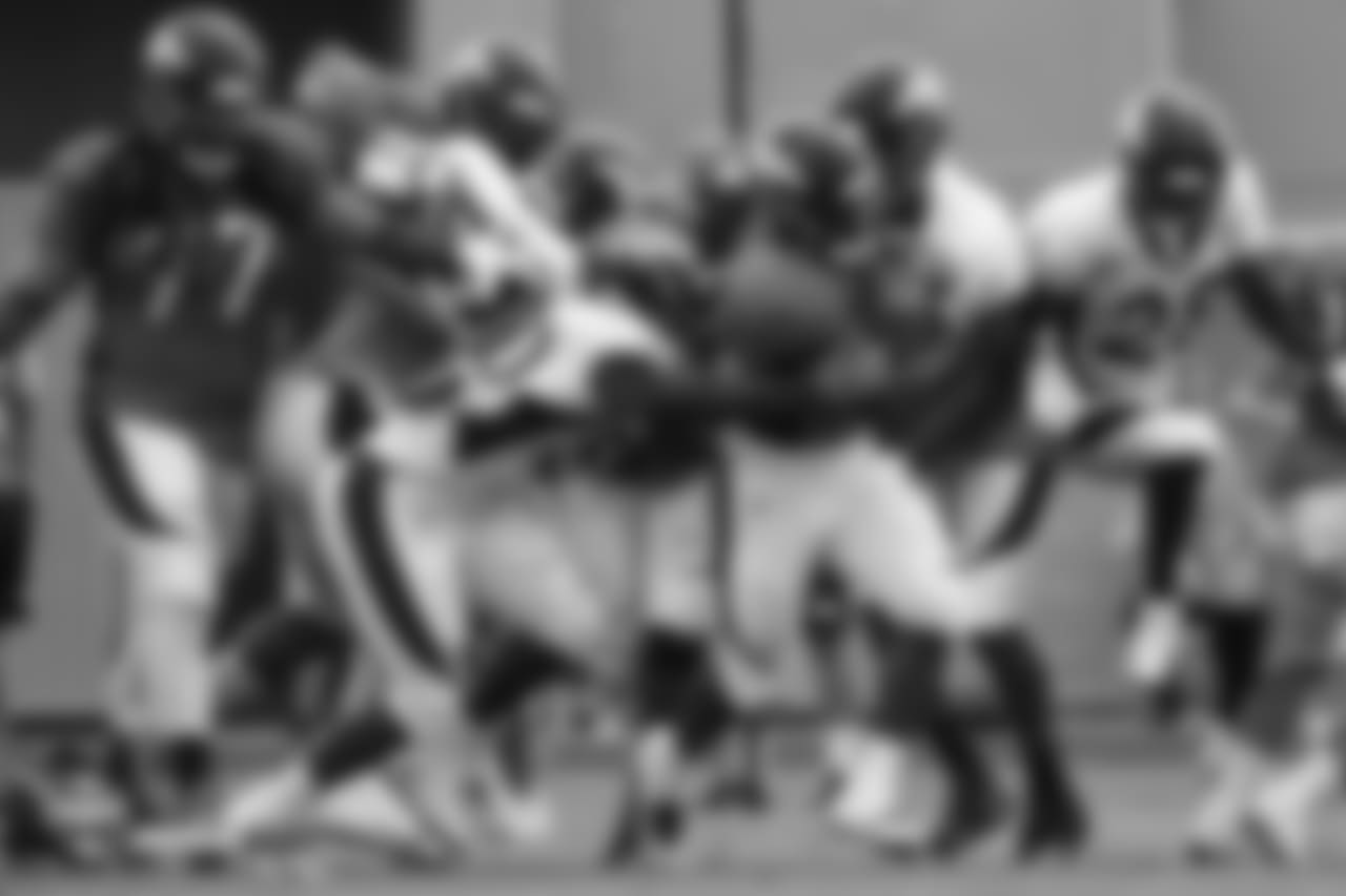 Running back De'Angelo Henderson Sr. (33) is swarmed by defenders at the fifth day of training camp on August 1, 2018, at UCHealth Training Center.