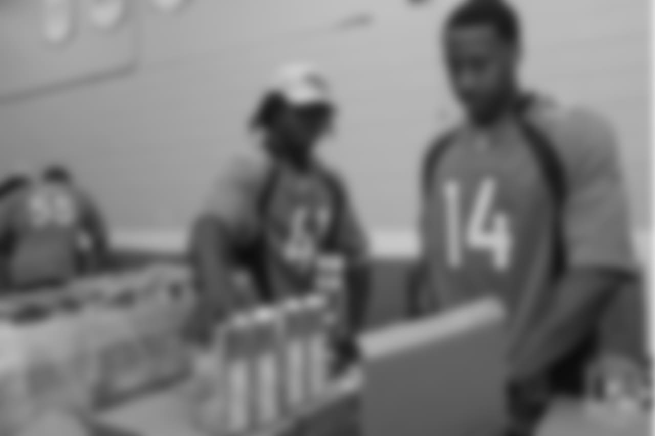 Cornerback Isaac Yiadom (41) and wide receiver Courtland Sutton (14) pack food at the Food Bank of the Rockies at the Broncos' third annual Rookie Community Service Day on June 11, 2018.