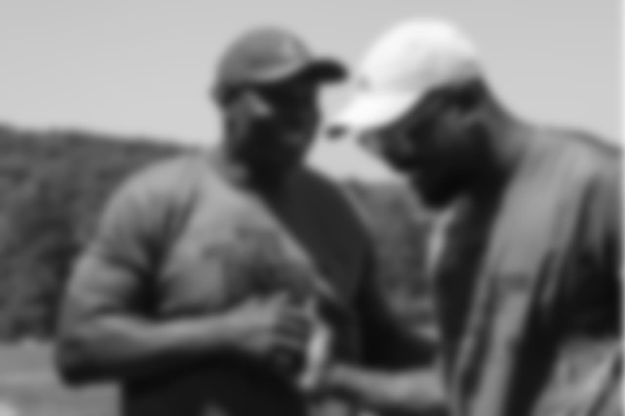 Von Miller and Bruce Smith share a laugh during the on-field portion of Von Miller's Pass Rush Summit, which included hands-on instruction and drills, on June 28, 2018.
