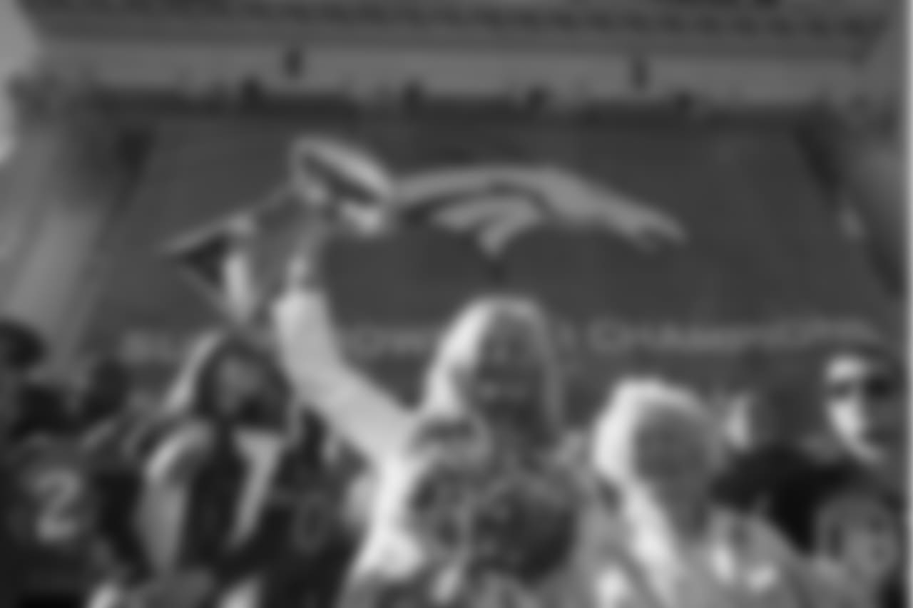 Annabel Bowlen holds up the Lombardi Trophy while standing with her family, including her mother, Joan Spencer, during the Broncos' Super Bowl 50 parade and celebration.