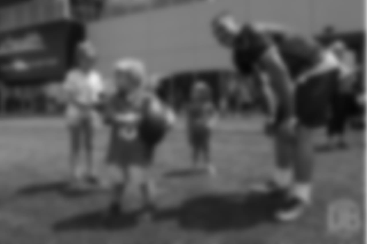 quarterback Chad Kelly (6) smiles as he hangs out with three children from Children's Hospital Colorado's burn unit after the final day of OTAs on June 7, 2018 at UCHealth Training Center. The young boy with the football had noticed the team's turf crew driving a large lawnmower as he and Kelly played catch