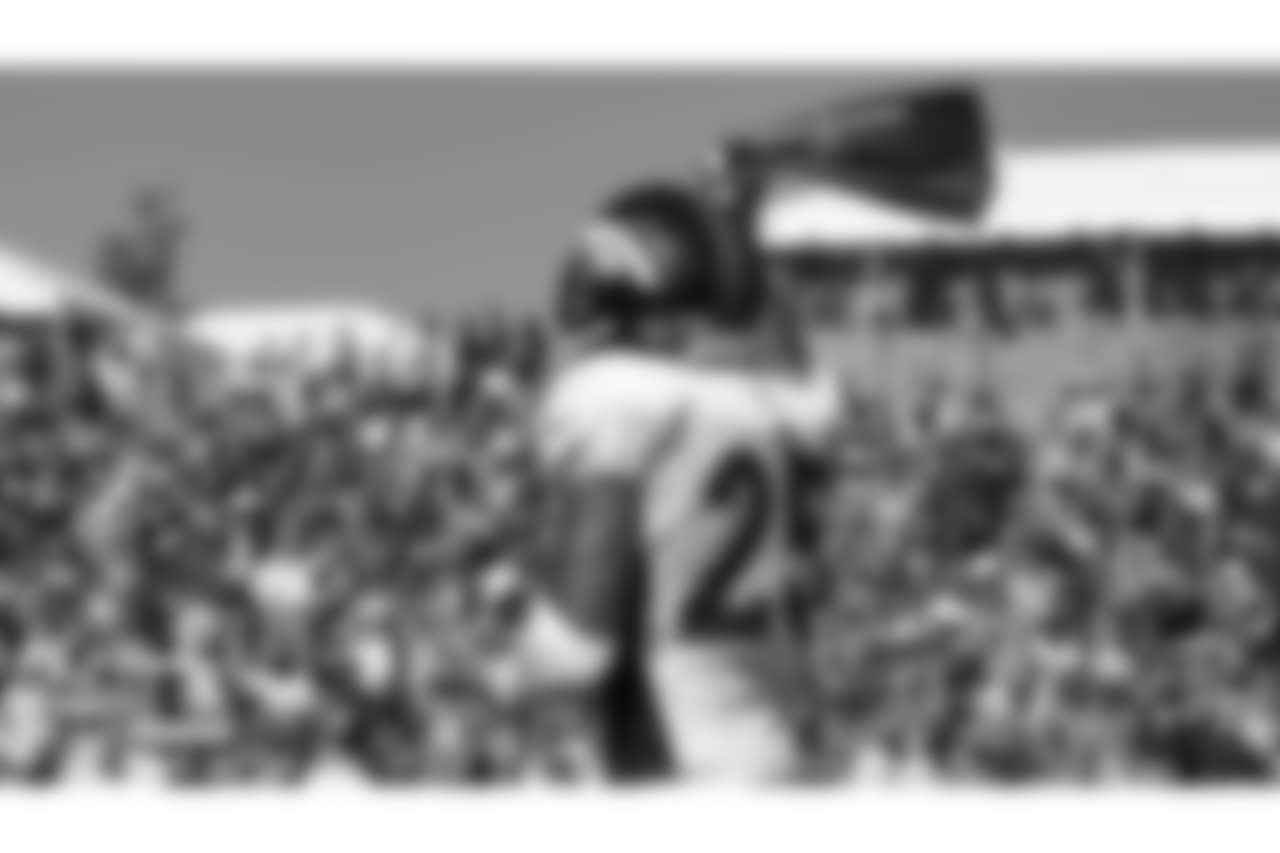 Cornerback Chris Harris Jr. (25) waves a towel for Alzheimer's Awareness Day during the seventh day of training camp on August 4, 2018, at UCHealth Training Center.