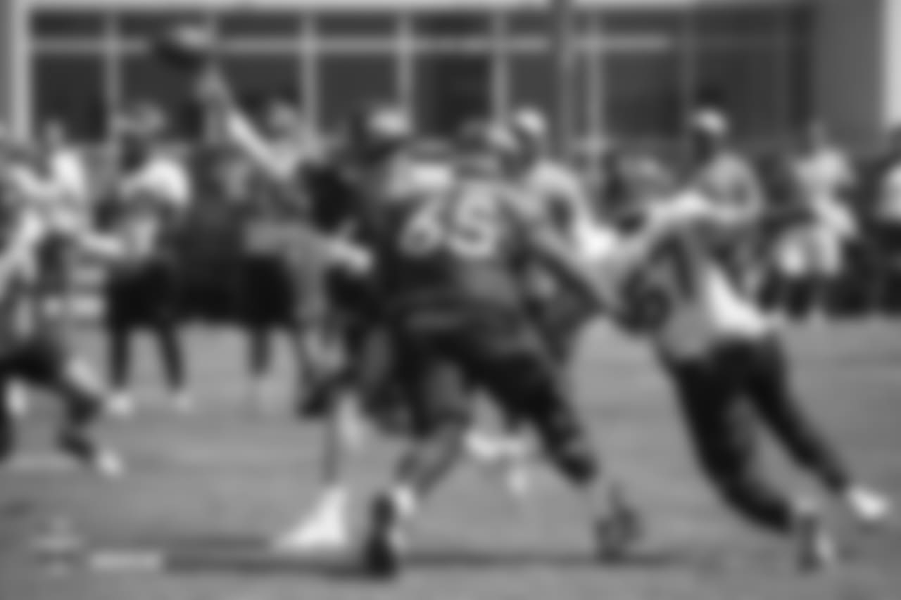 Quarterback Case Keenum (4) passes out of the pocket as defensive end DeMarcus Walker (57) applies pressure during the 11th day of training camp on August 9, 2018, at UCHealth Training Center.