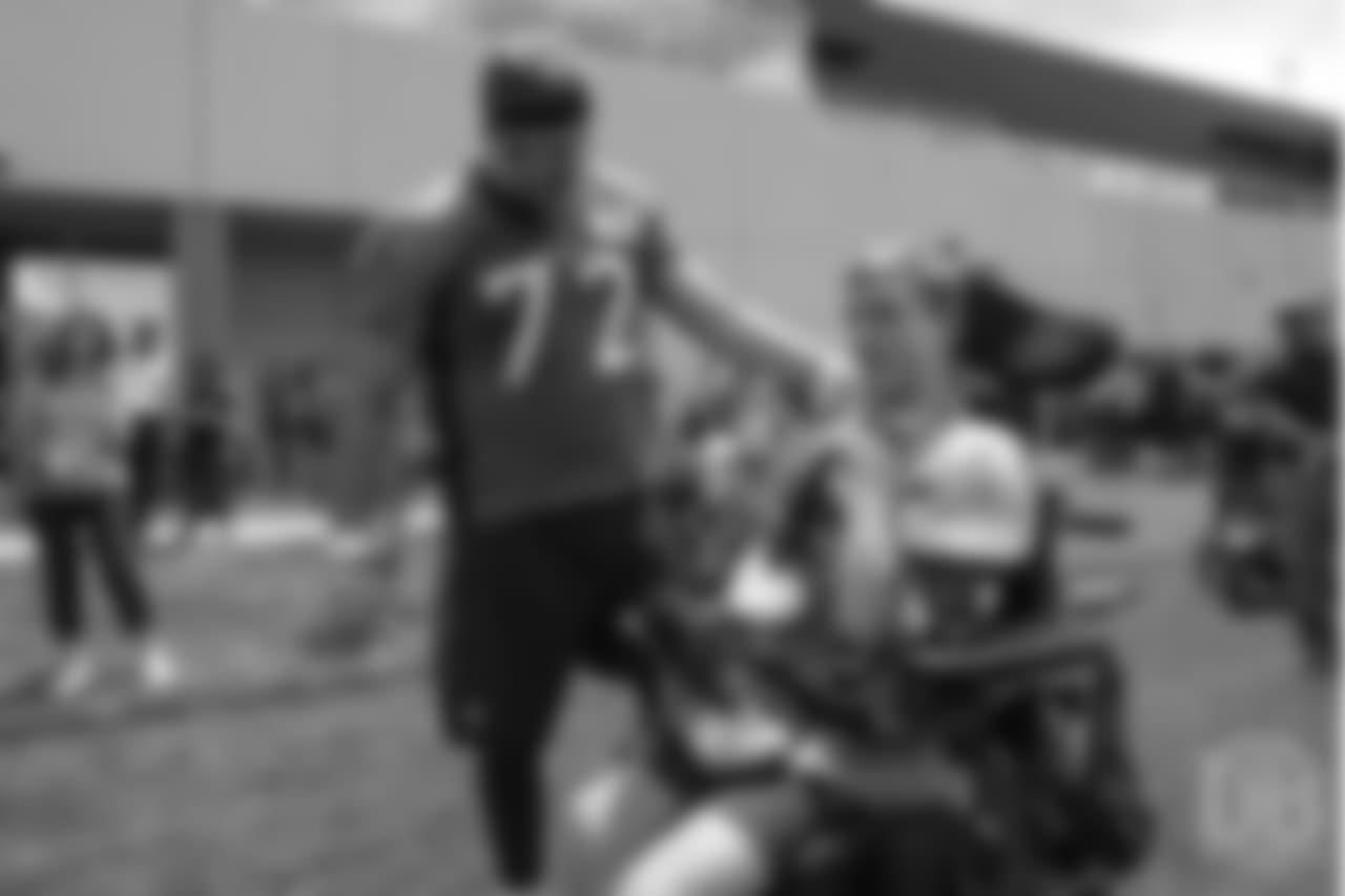 tackle Garett Bolles (72) giving away autographed cleats to a patient from Children's Hospital Colorado's burn unit after the final day of OTAs on June 7, 2018 at UCHealth Training Center.