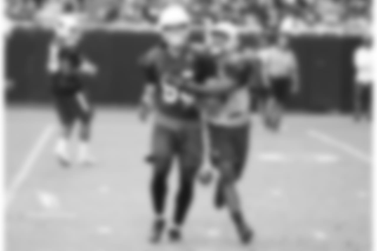 WR Krishawn Hogan (left) is grabbed by S Budda Baker