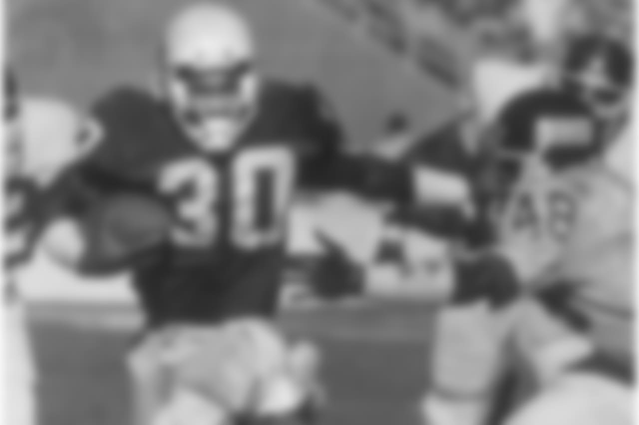 RB Stump Mitchell stiff-arms New York's Kenny Hill in 1988