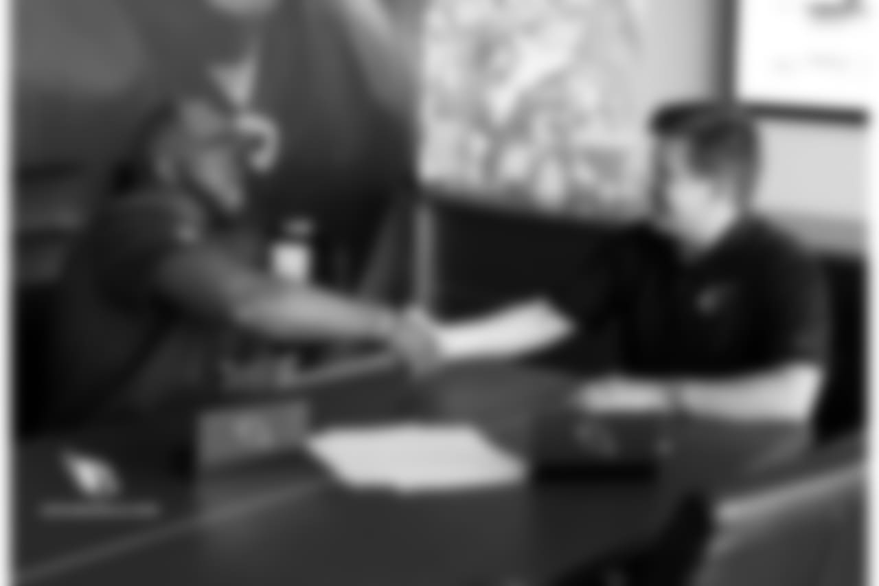 T Korey Cunningham shakes the hand of team president Michael Bidwill after signing his contract