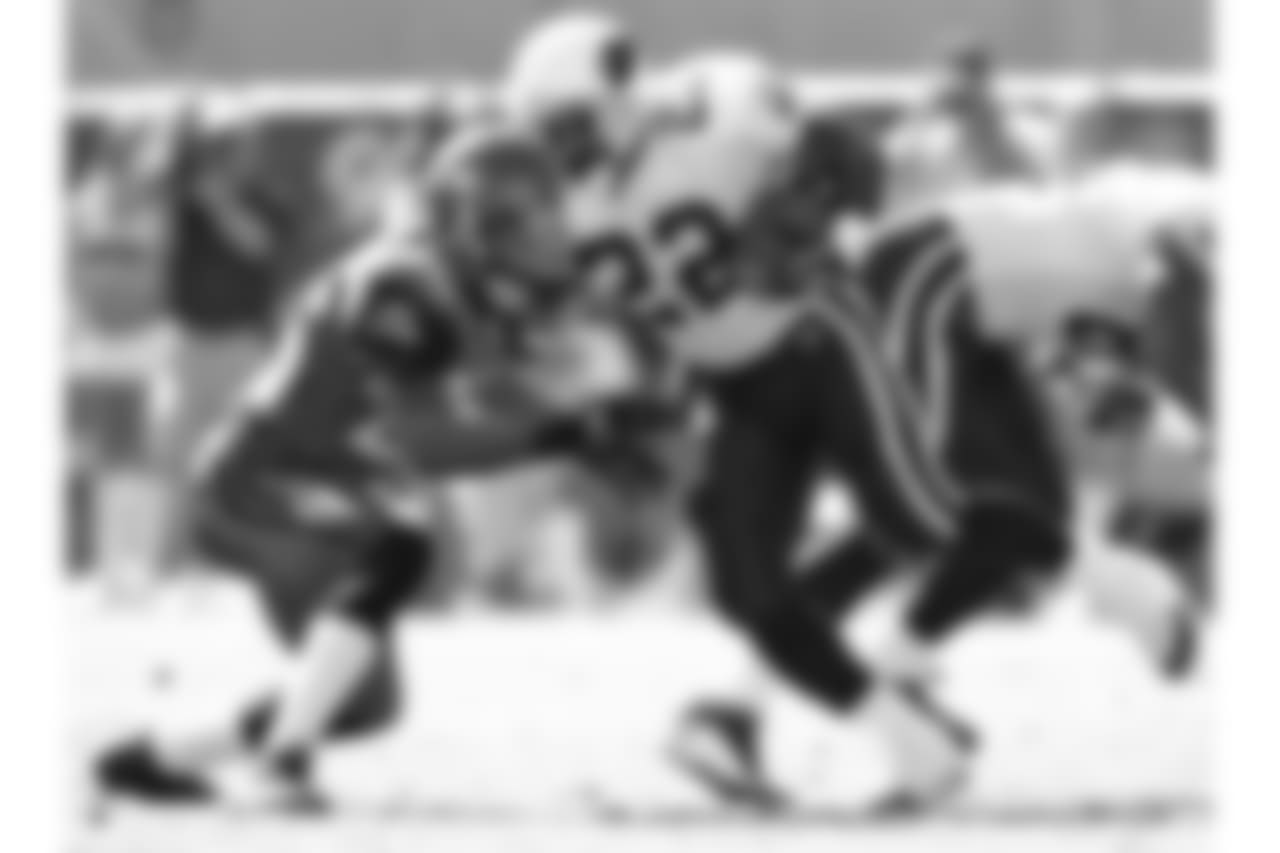 2004: RB Emmitt Smith rushes the ball and is tackled by Seattle's Ken Hamlin
