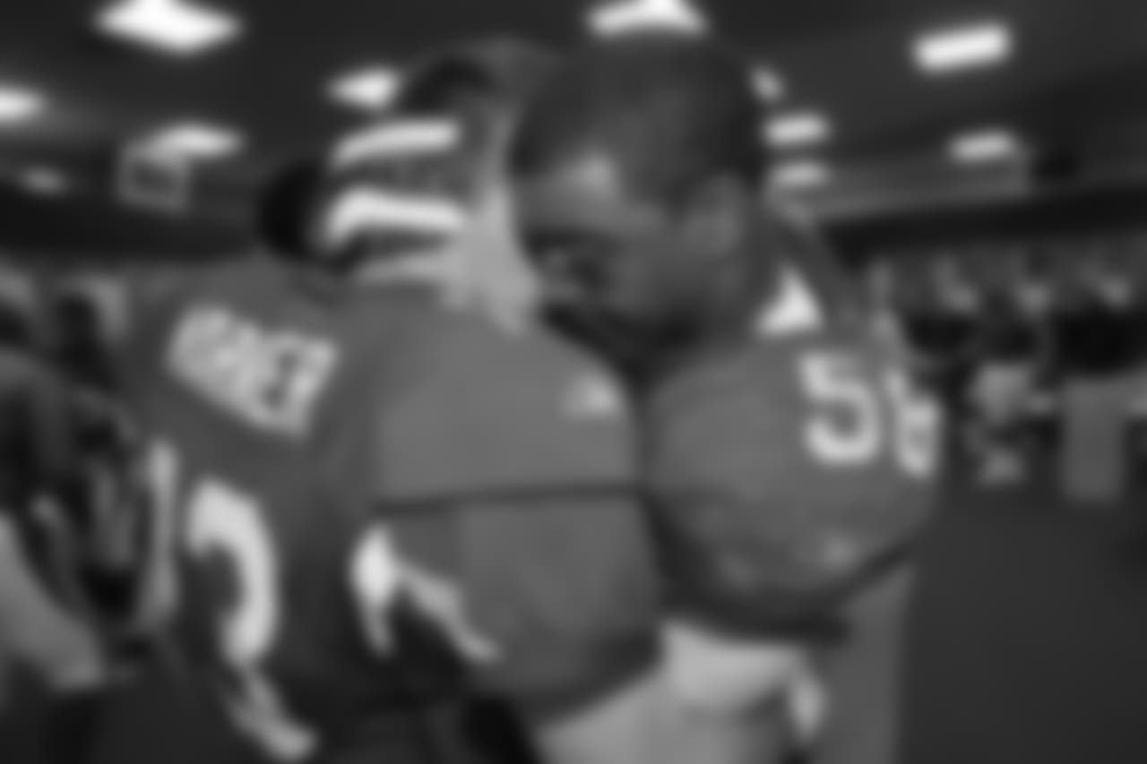 Warner hugs LB Karlos Dansby after winning the NFC title against the Eagles