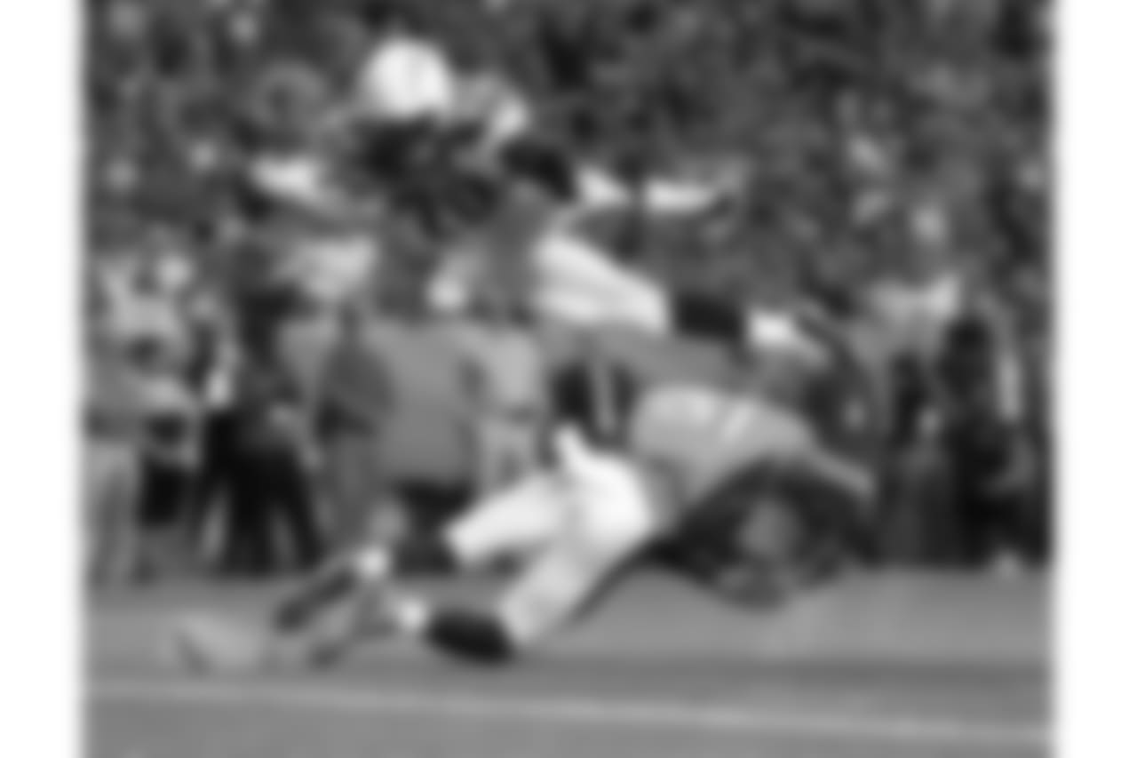 Los Angeles Chargers running back Melvin Gordon (28) dives over Denver Broncos strong safety Justin Simmons (31) for a touchdown during the first half of an NFL football game, Monday, Sept. 11, 2017, in Denver. (AP Photo/Jack Dempsey)