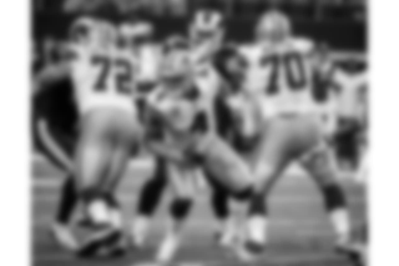 Dallas Cowboys' Travis Frederick (72) and Zack Martin (70) defend as quarterback Dak Prescott (4) scrambles under pressure from Los Angeles Rams defensive tackle Michael Brockers, rear, in the second half of an NFL football game, Sunday, Oct. 1, 2017, in Arlington, Texas. (AP Photo/Michael Ainsworth)