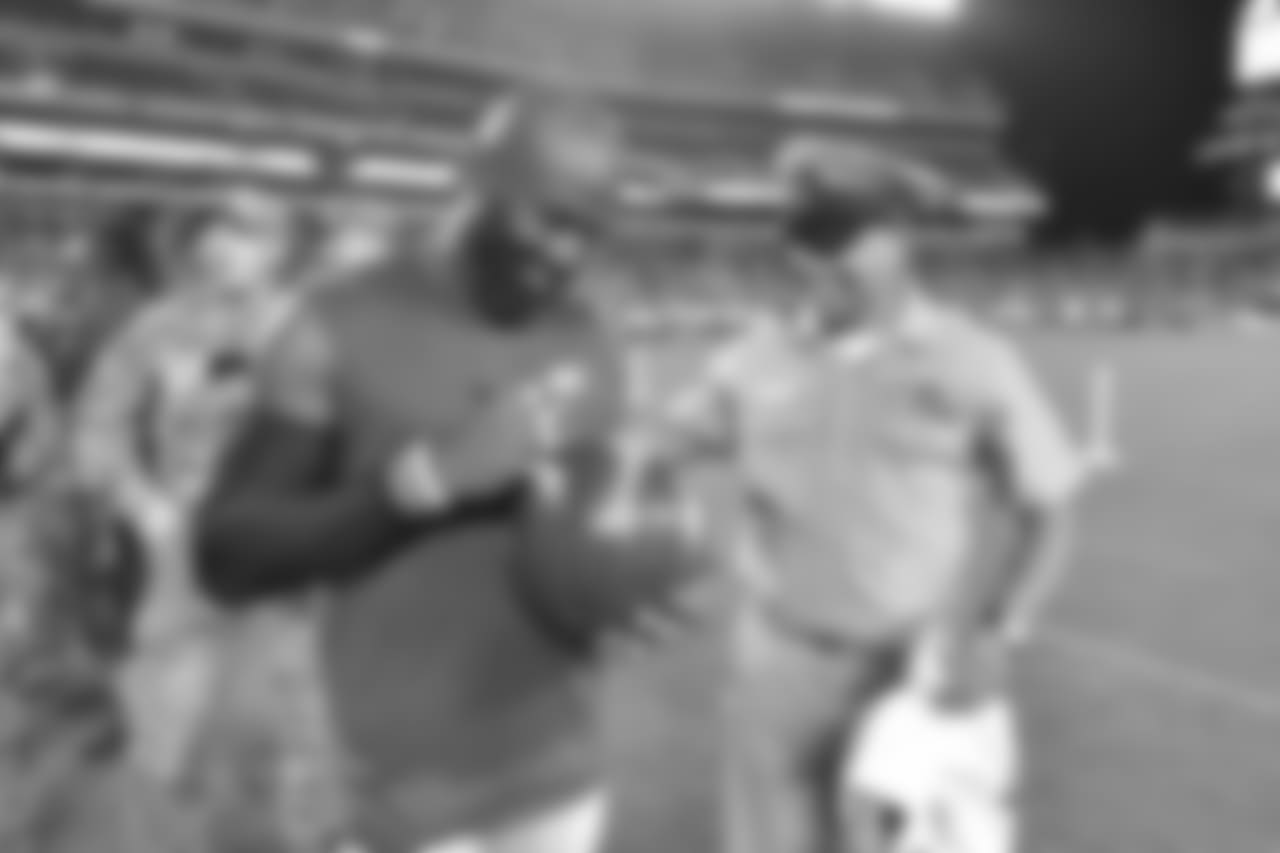 S Malcom Jenkins autographs a ball for a military member.