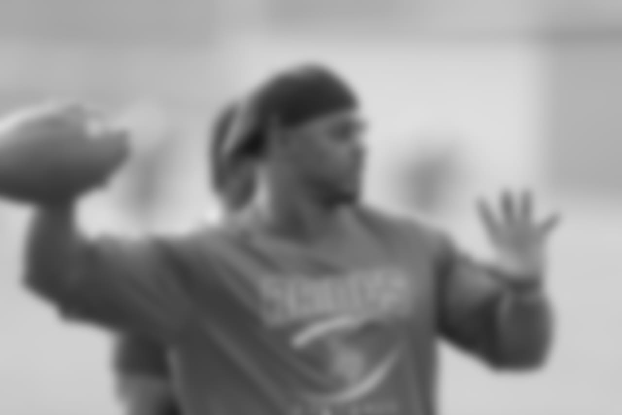 Brian Dawkins throws a football to a Raines player during practice