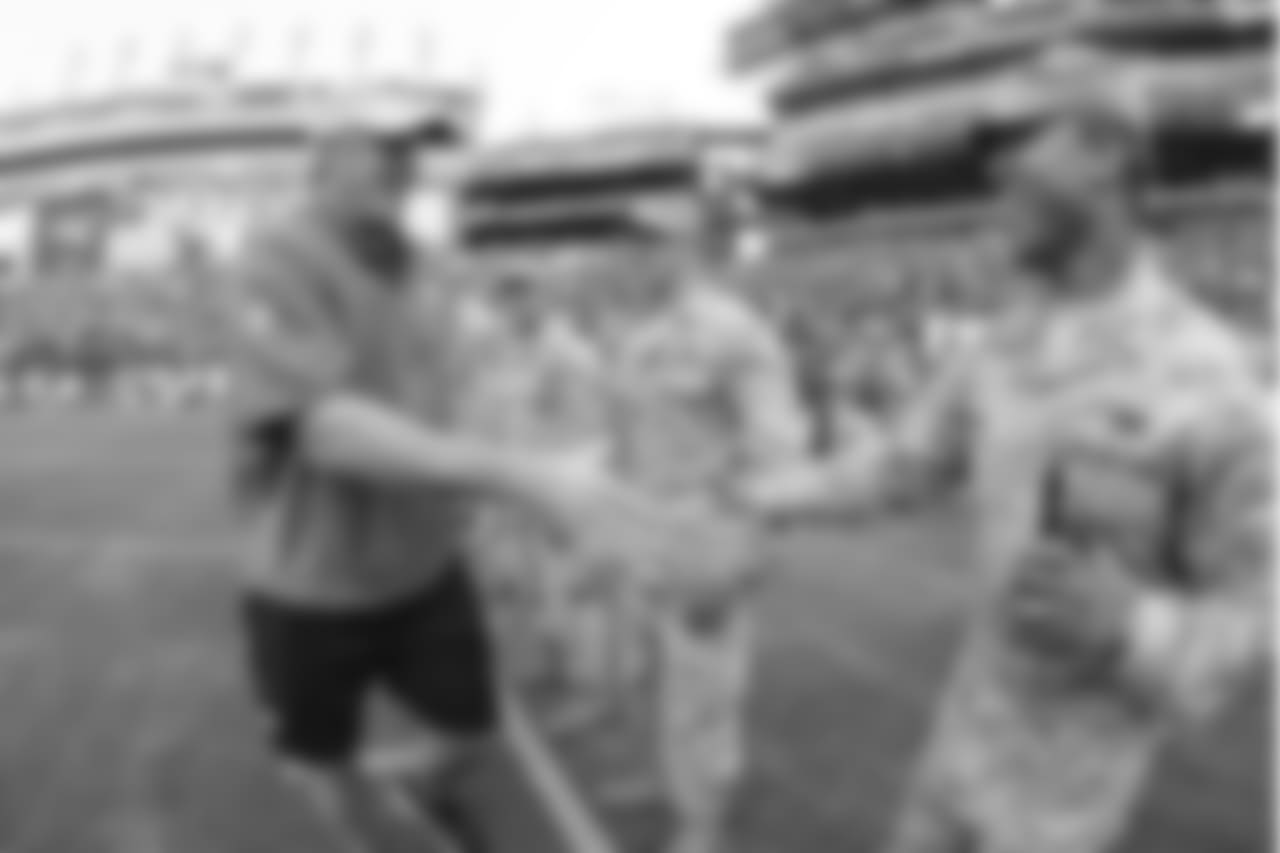 Head coach Doug peterson shakes military members hands.