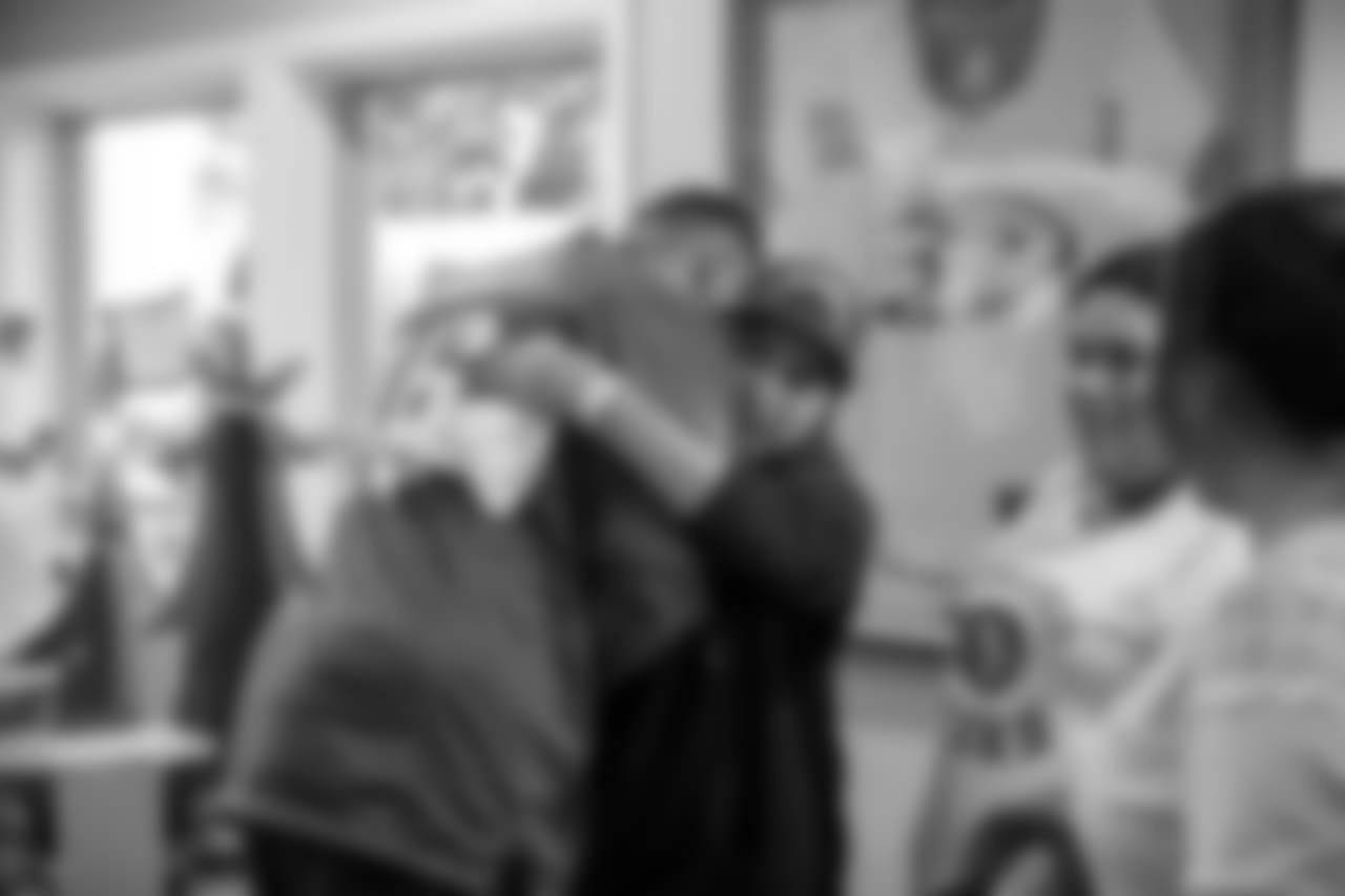 DE Derek Barnett hugging one of the children.