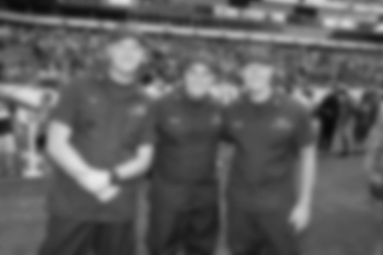 Military members pose for a picture on the field.