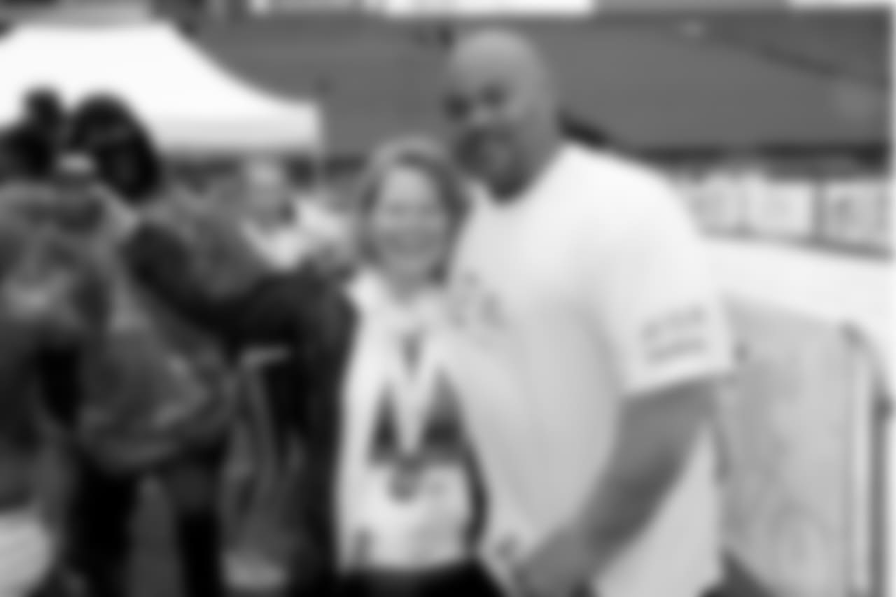 Assistant head coach Duce Staley takes a photo with a fan.