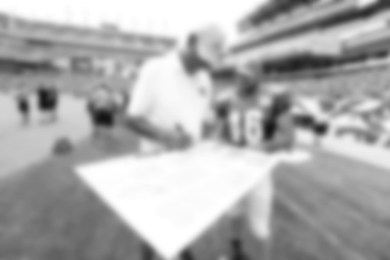 Harold Carmichael and Jon Dorenbos signing a poster.