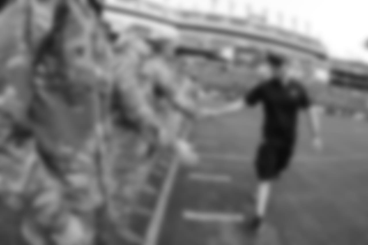 Howie Roseman shakes hands with military members.