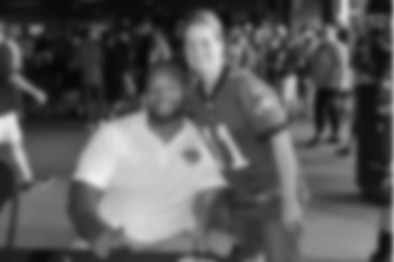 Eagles Alumni, DT Darwin Walker takes a photo with a young fan.