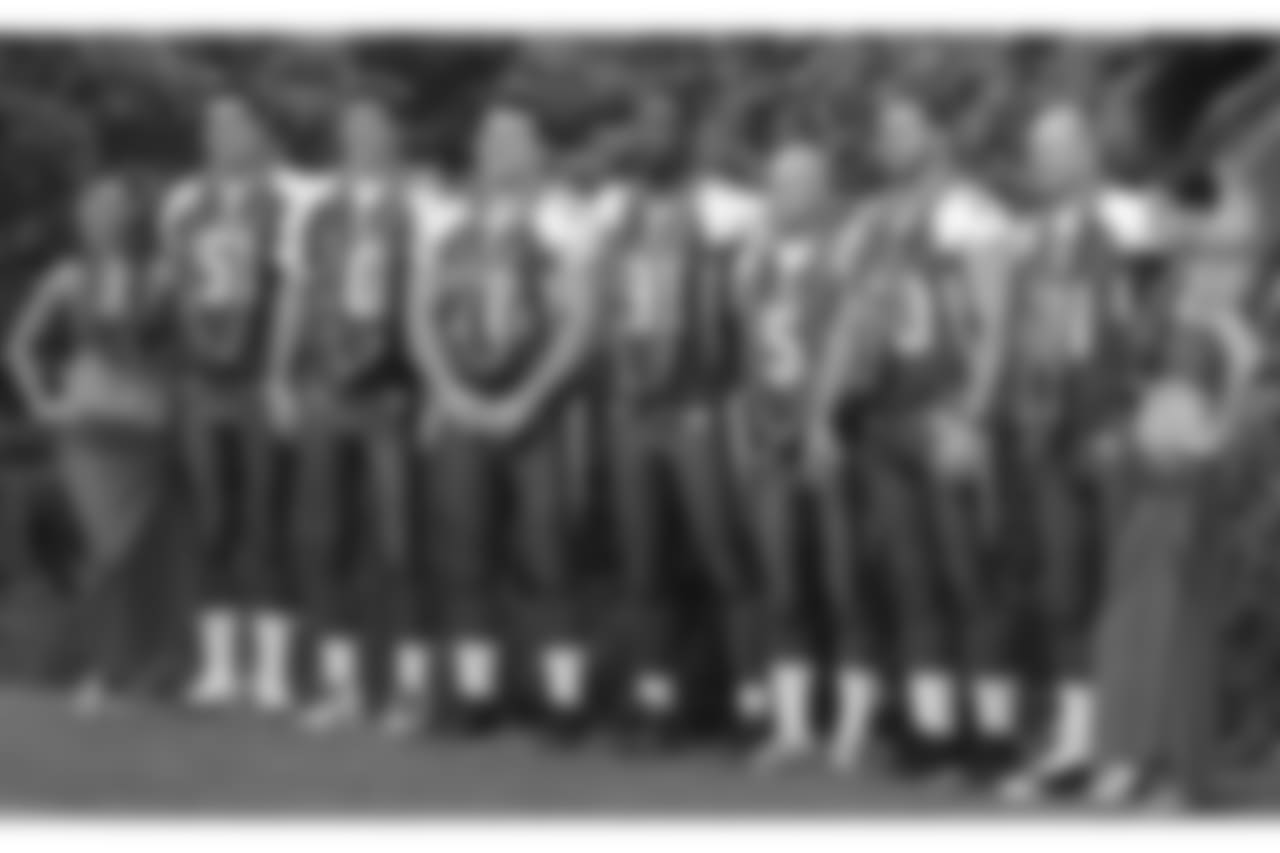 New York Giants football players from left to right, Zak DeOssie (51), Eli Manning (10), Chris Snee (76), Justin Tuck (91), John Carney (5), Shaun O'Hara (60), and Jeff Feagles (18) pose for photos with hula dancers before an NFC practice.
