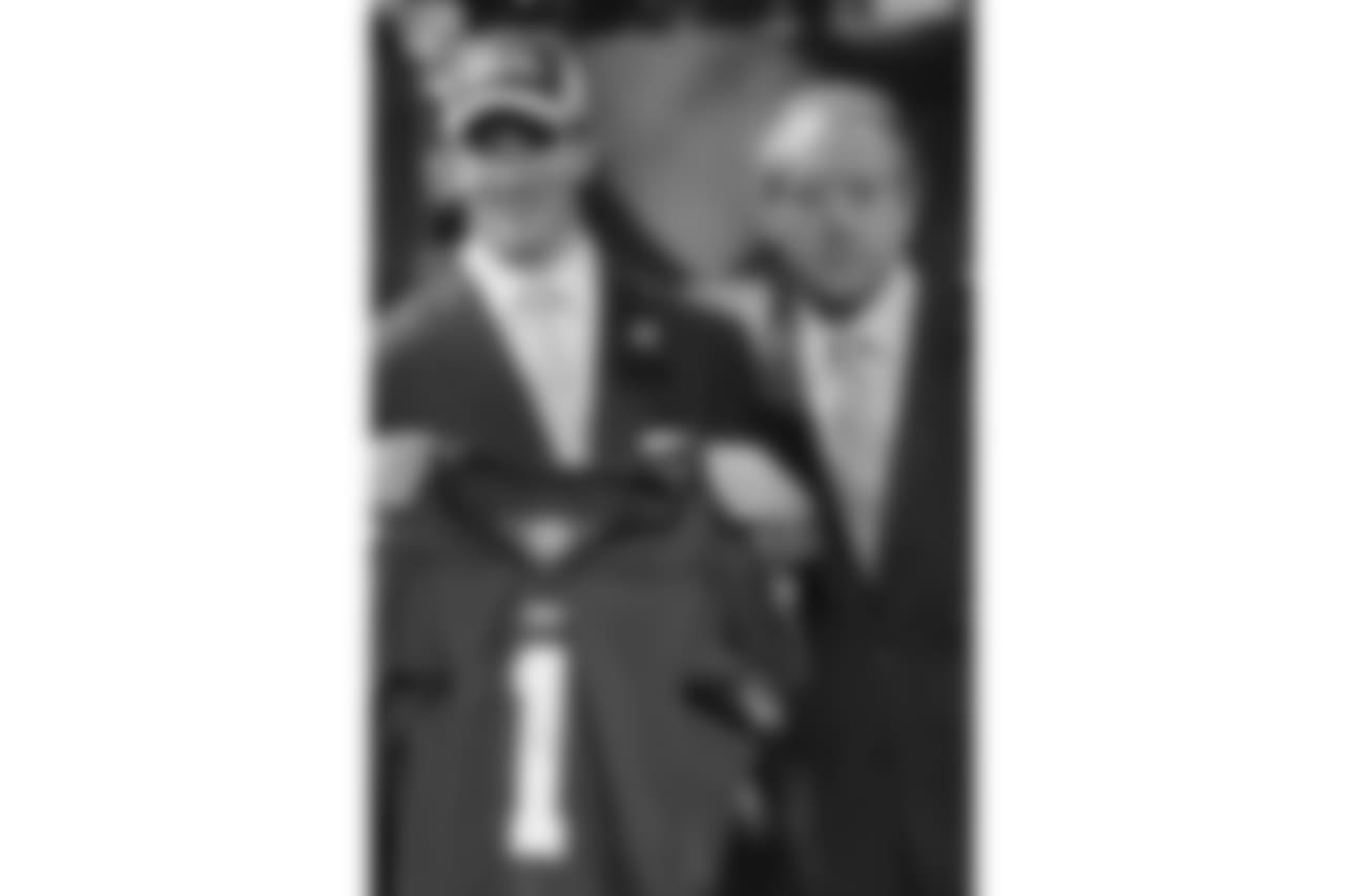 Eli Manning, left, a quarterback from Mississippi, holds a New York Giants jersey as he stands with his father, Archie, at the NFL draft Saturday, April 24, 2004 in New York. Manning was the first pick of the 2004 draft by the San Diego Chargers and was later traded to the New York Giants. (AP Photo/John Marshall Mantel)