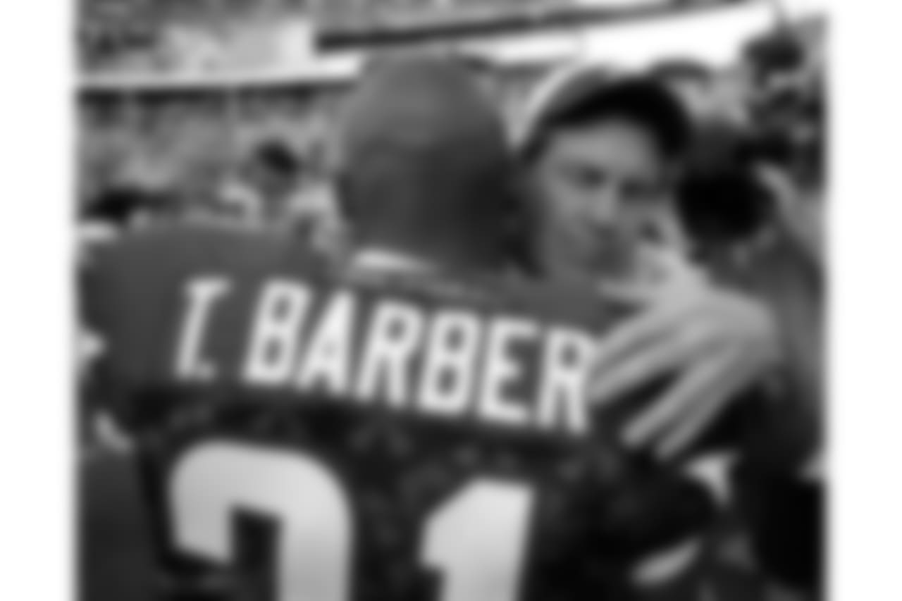 AFC head coach Bill Belichick (facing camera) and NFC New York Giants running back Tiki Barber, who is retiring from pro football, embrace on the field following the Pro Bowl football game at Aloha Stadium in Honolulu Saturday, Feb. 10, 2007.
