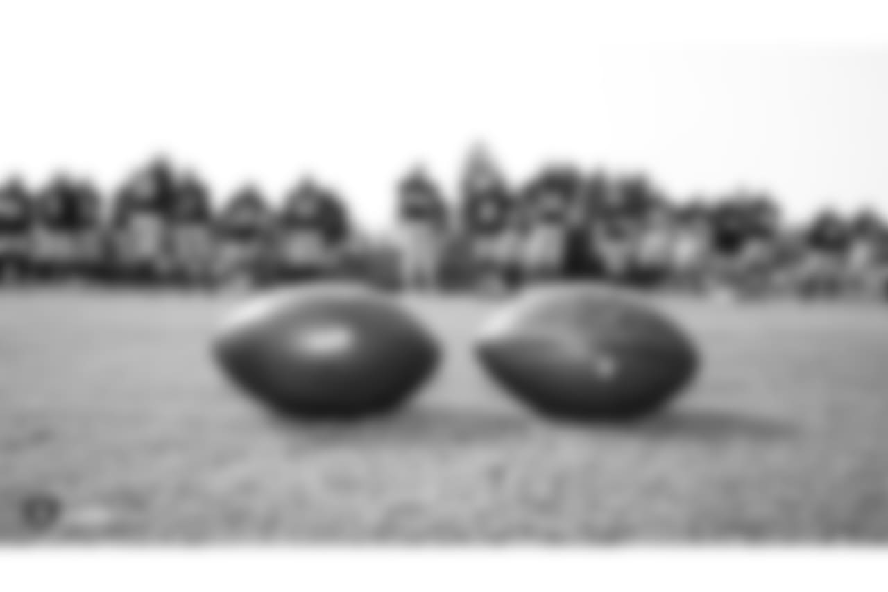 Oakland Raiders footballs with players in the background on the field for practice at 2018 Training Camp at The Oakland Raiders Napa Valley Training Complex, Monday, August 7, 2018, in Napa, California.