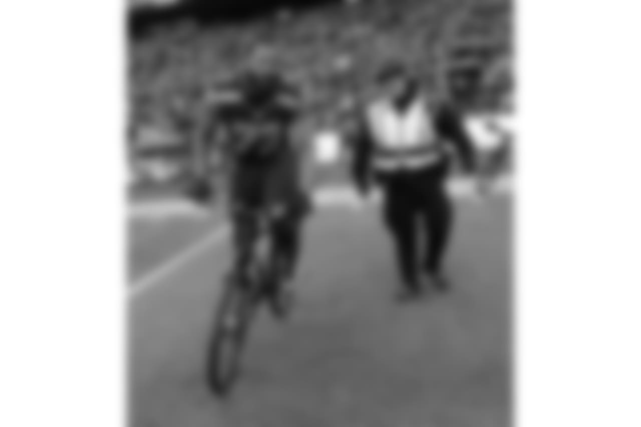 Seattle Seahawks' Michael Bennett borrows a police officers bike after overtime of the NFL football NFC Championship game against the Green Bay Packers Sunday, Jan. 18, 2015, in Seattle. The Seahawks won 28-22 to advance to Super Bowl XLIX. (AP Photo/David J. Phillip)