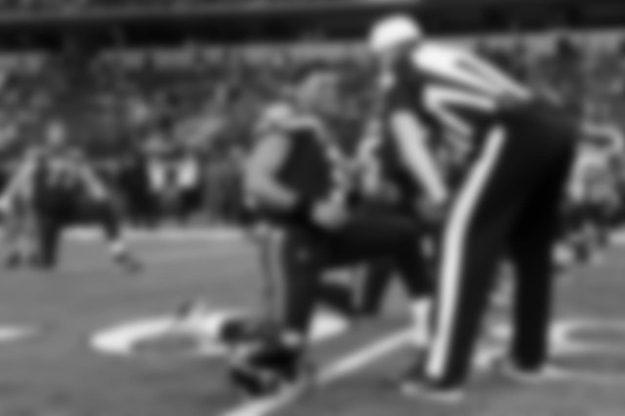 Seahawks quarterback Russell Wilson talks with the head referee during team stretch.