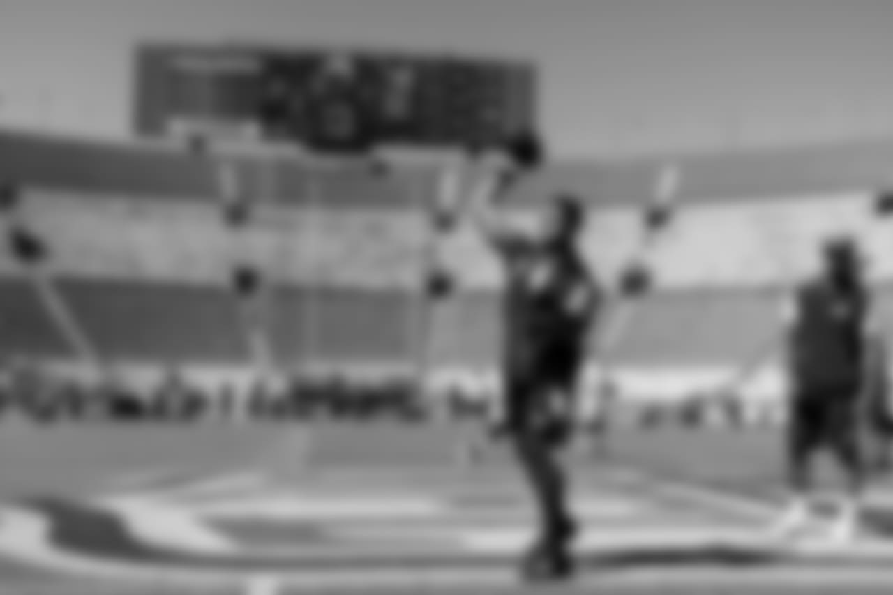 Quarterback Russell Wilson takes his early warmup throws on the NFL logo painted at midfield at Los Angeles Memorial Coliseum prior to facing the Rams.