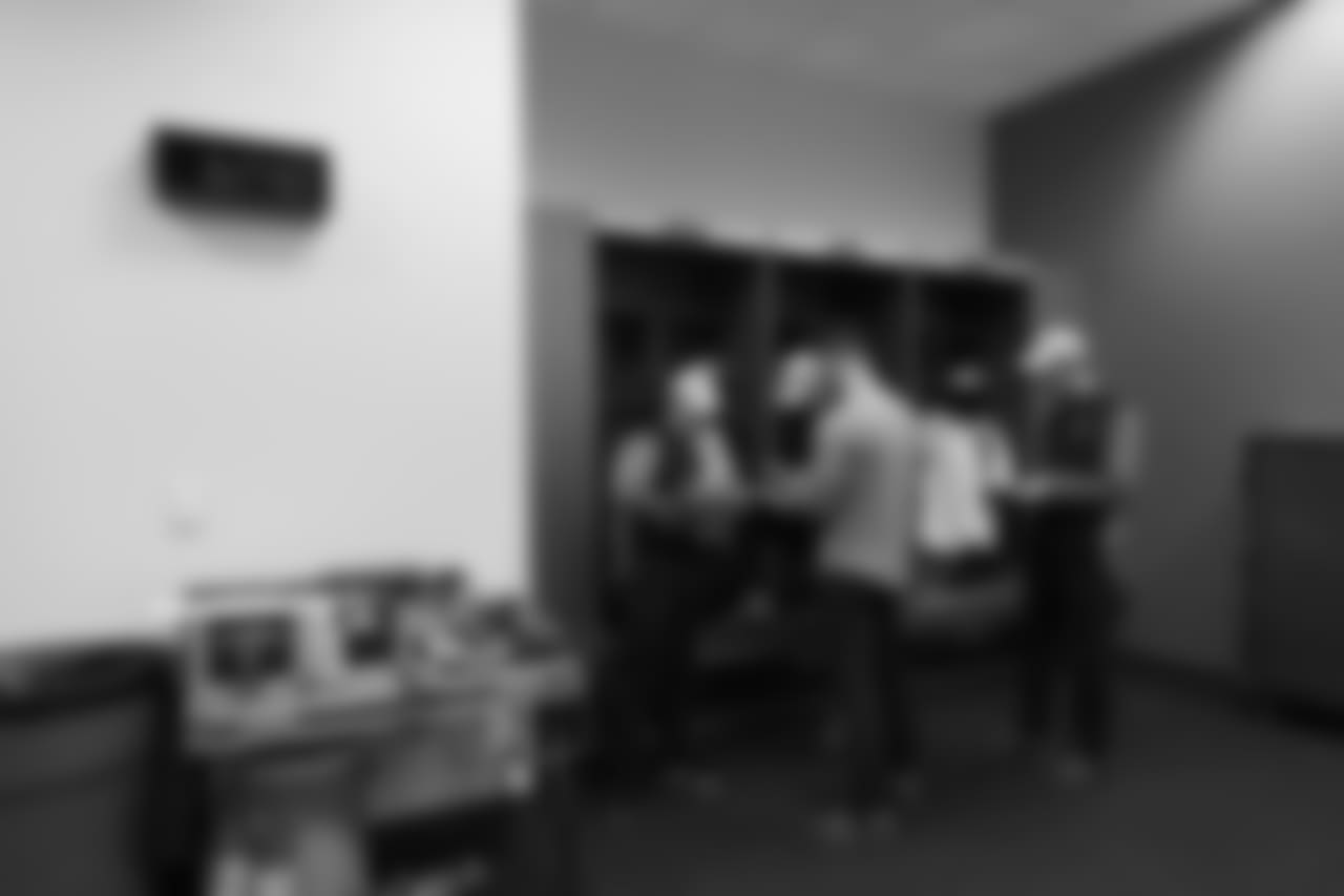 Offensive assistants including Will Harriger, Darrell Bevell, David Canales and Nate Carroll gather for a quick strategy session in the locker room at halftime.