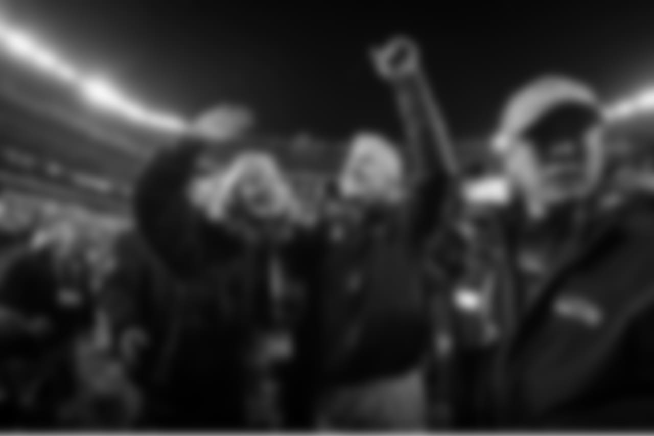 Head coach Pete Carroll and his wife Glena wave to Seahawks fans as they make their way off the field after the game.