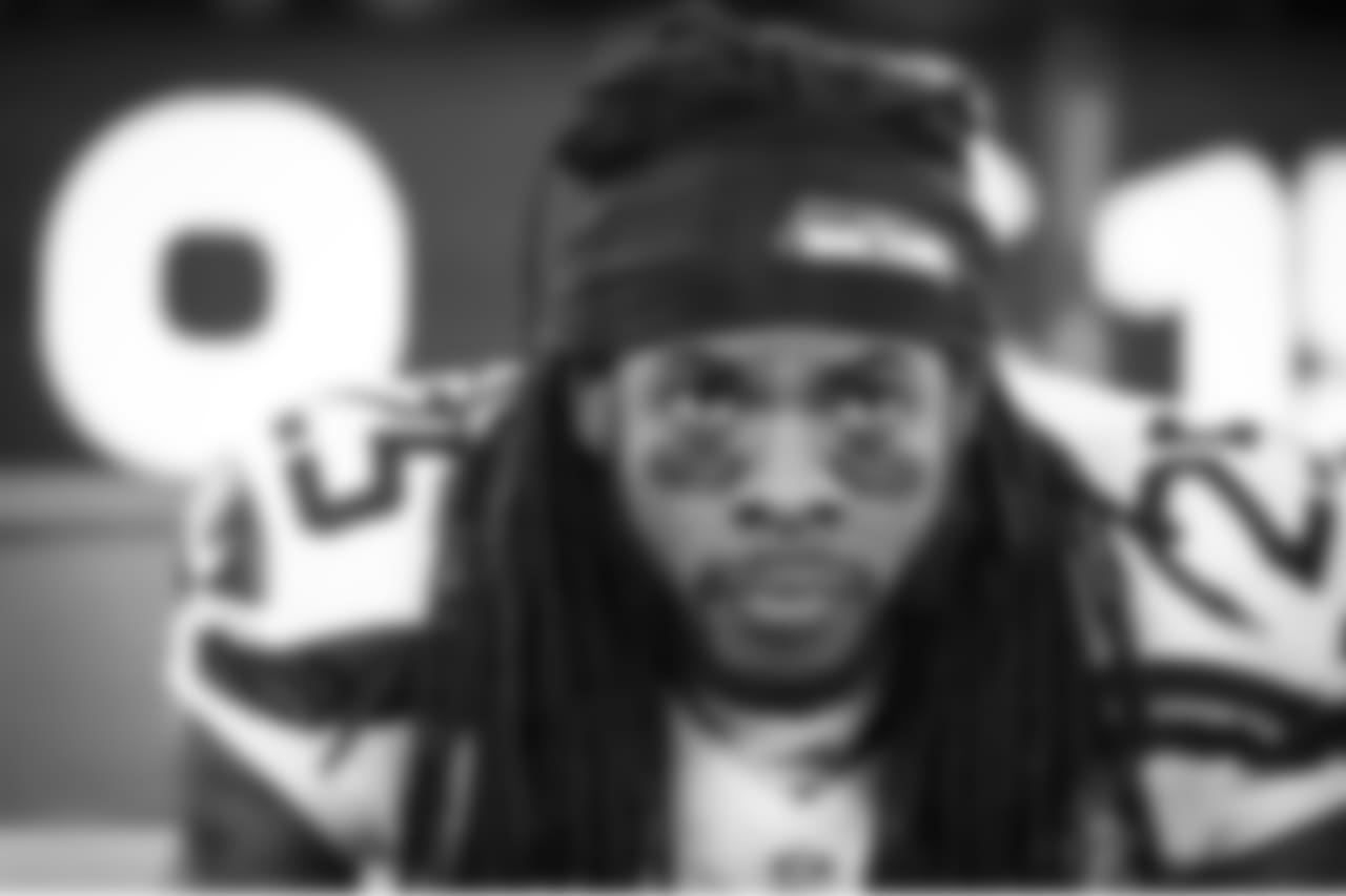 Cornerback Richard Sherman focuses while sitting on the sidelines during the extended pregame ceremonies of the Super Bowl.