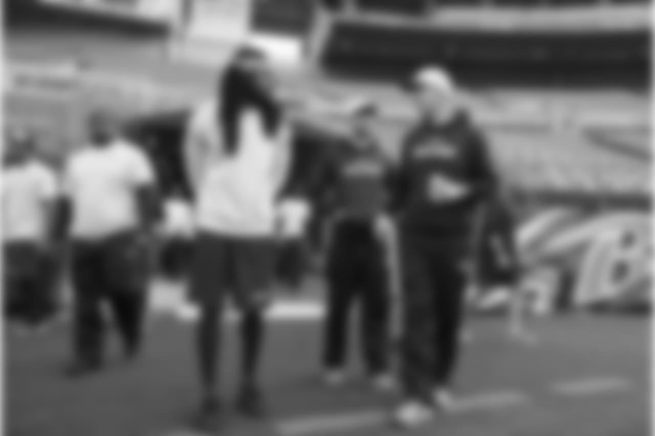 Richard Sherman, assistant coach Nate Carroll and offensive coordinator Darrell Bevell chat as they walk onto the turf at M&T Stadium on Saturday afternoon.