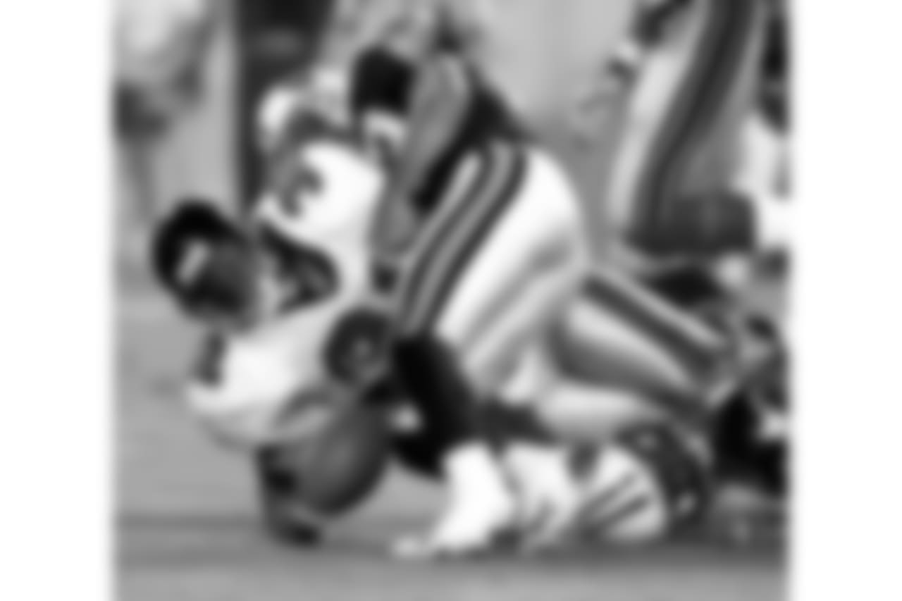 Atlanta Falcons running back Jamal Anderson (32) fumbles the ball after being hit by Tennessee Titans' Jevon Kearse, bottom right, and Blaine Bishop on Friday, Aug. 27, 1999, in Nashville, Tenn. Tennessee's Marcus Robertson recovered the ball. (AP Photo/Chris Berkey)