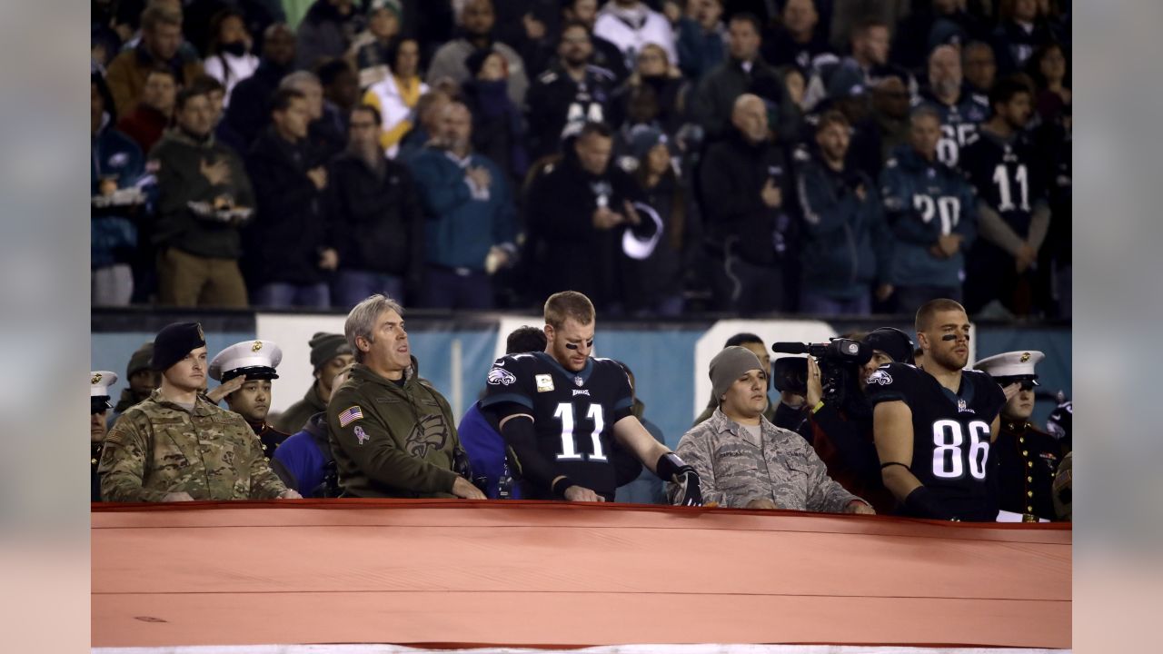 Service members from all five branches of the armed services carry a large  American flag out onto the field at the Salute to Service Chicago Bears  game Nov. 27 at Soldier Field