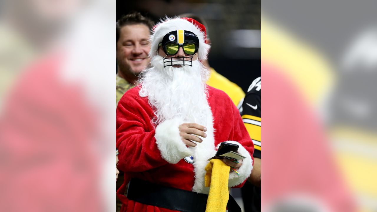 An Arizona Cardinals fan, dressed as Santa Claus, cheers during the first  half of an NFL football game against the Indianapolis Colts, Saturday, Dec.  25, 2021, in Glendale, Ariz. (AP Photo/Rick Scuteri