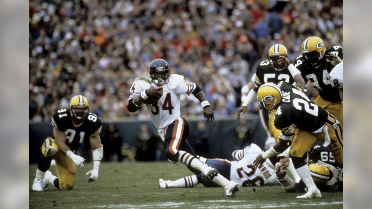 Chicago Bears' Walter Payton (34) comes in for a landing on top of