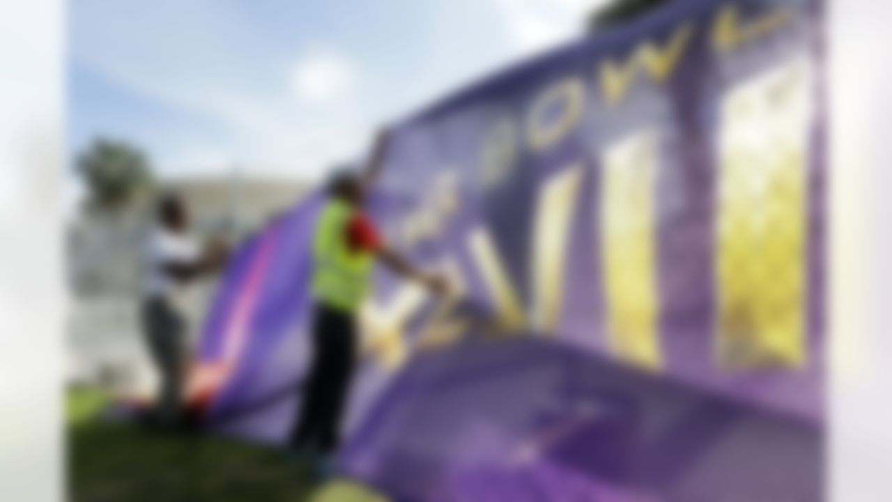 Emmanuel Joiner, left, and Kendrick Mills secure a screen over a fence that surrounds the Mercedes-Benz Superdome as crews prepare for the NFL Super Bowl XLVII football game on Sunday, Jan. 27, 2013, in New Orleans. The Baltimore Ravens and San Francisco 49ers are scheduled to play in Super Bowl XLVII on Sunday, Feb. 3. (AP Photo/Patrick Semansky)