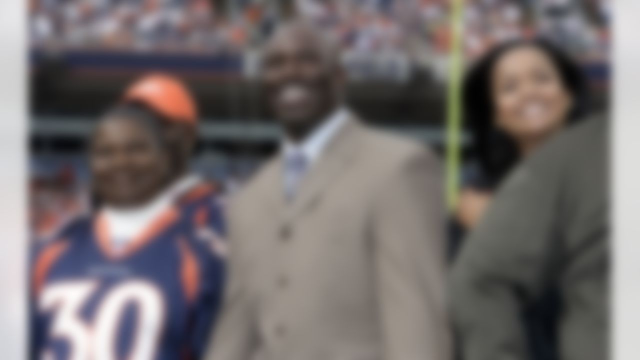 Family members surround retired Denver Broncos running back Terrell Davis, center, as he is honored during a halftime ceremony to induct him into the team's "Ring of Fame" in the Jacksonville Jaguars' 24-13 victory over the Broncos in a football game in Denver on Sunday, Sept. 23, 2007. (AP Photo/David Zalubowski)
