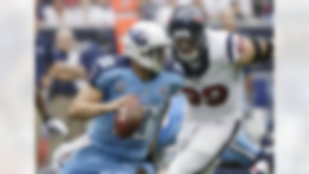 Tennessee Titans' Jake Locker (10) is chased by Houston Texans' J.J. Watt (99) as he looks to pass during the first quarter of an NFL football game on Sunday, Sept. 15, 2013, in Houston. (AP Photo/Patric Schneider)