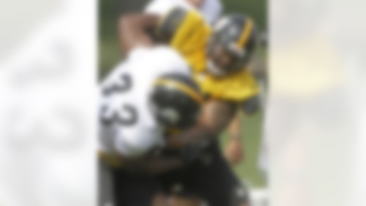 Pittsburgh Steelers linebacker LaMarr Woodley, top, tangles with running back Isaac Redman (33) as the two participate in a blocking drill during practice at the NFL football training camp in Latrobe, Pa. on Saturday, July 28, 2012 . (AP Photo/Keith Srakocic)