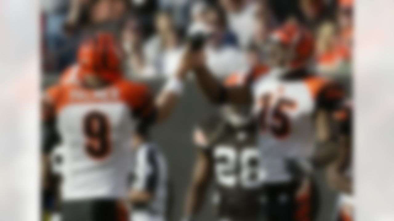 Cincinnati Bengals wide receiver Chris Henry (15) is congratulated by Bengals quarterback Carson Palmer (9) after catching a 7-yard touchdown pass during second quarter action of their NFL football game in Cleveland, Sunday, Nov. 26, 2006. (AP Photo/Ron Schwane)