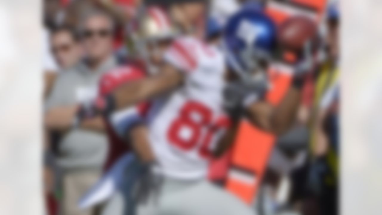 New York Giants wide receiver Victor Cruz (80) holds the ball against his helmet while catching a pass in front of San Francisco 49ers cornerback Carlos Rogers (22) during the second quarter of an NFL football game in San Francisco, Sunday, Oct. 14, 2012. (AP Photo/Mark J. Terrill)