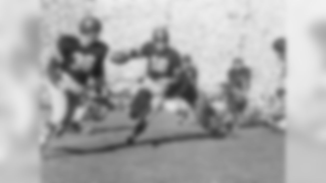 Frank Gifford (16), USC halfback, is about to be brought down by California's Les Richter, defensive guard, after a short gain in this second quarter play in Berkeley, Calif., Oct. 20, 1951. Pat Duff (36) is seen at left. (AP Photo)