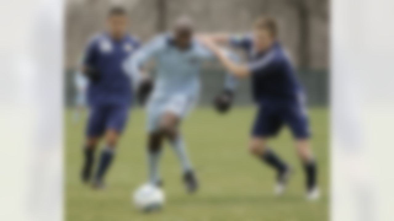 NFL star Chad Ochocinco, center, moves the ball past a pair of unidentified defenders as he plays in a reserve soccer match as part of his tryout with the Sporting Kansas City MLS soccer team, Monday, March 28, 2011, in Kansas City, Mo. With the NFL in a lockout, Ochocinco, a wide receiver for the Cincinnati Bengals, has said that it is a good time to check into another sport. (AP Photo/Charlie Riedel)