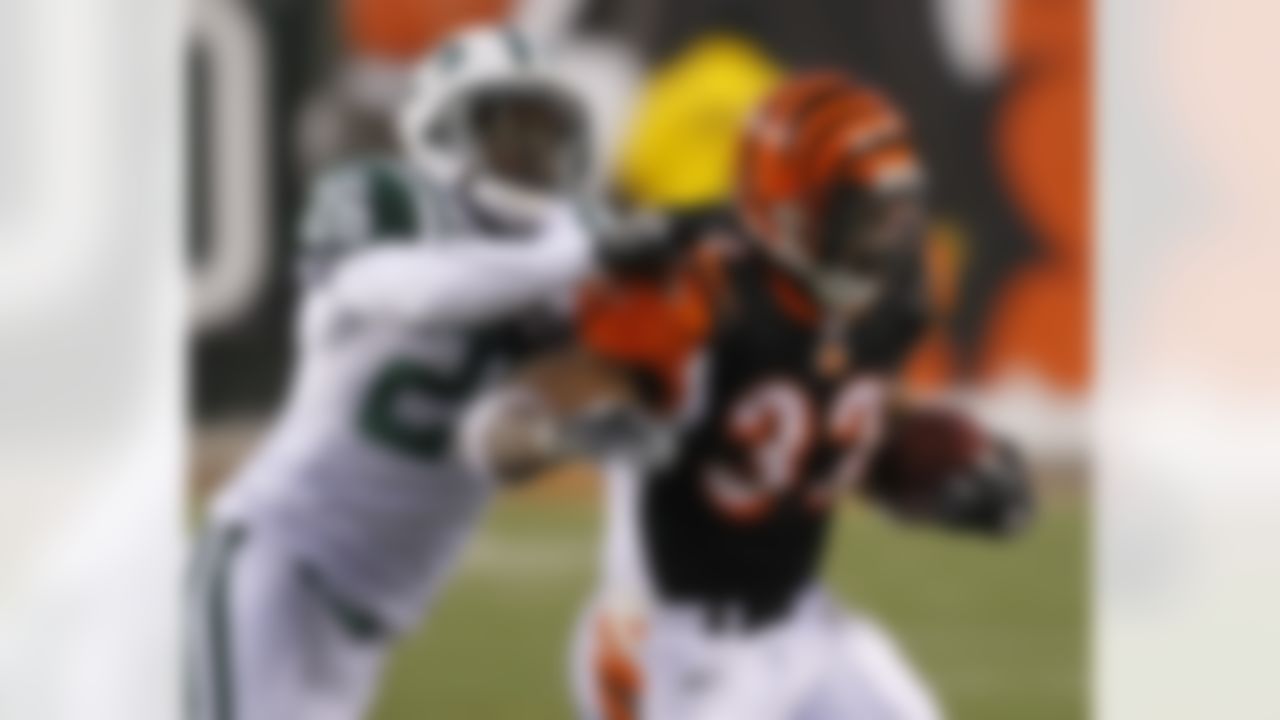 Cincinnati Bengals running back Cedric Benson (32) is tackled by New York Jets cornerback Lito Sheppard (26) in the first half of an NFL wild-card playoff football game, Saturday, Jan. 9, 2010, in Cincinnati. (AP Photo/Ed Reinke)